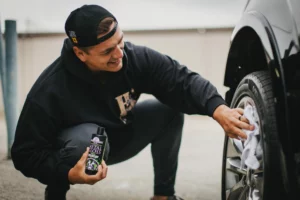 Man polishing car tires with metal gloss