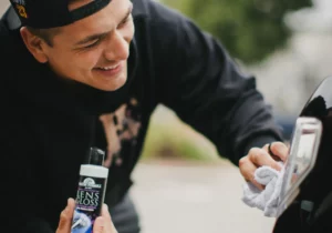 Man polishing car with lens gloss product